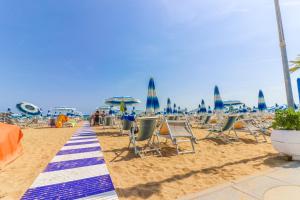 a sandy beach with chairs and umbrellas on it at Hotel Jesulum in Lido di Jesolo