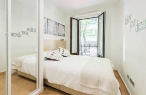 マドリードにあるCozy Goya-Salamanca Flatのベッドルーム(白いベッド1台、鏡付)