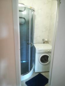 a bathroom with a shower and a washing machine at Couple getaway to a freshly renovated apartment in Pärnu