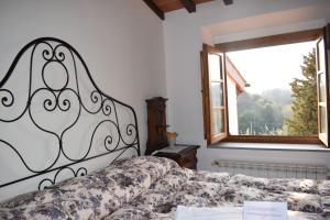 ラストラ・ア・シーニャにあるAgriturismo Villani Poderi Nesti & Cupoliのベッドルーム(ベッド1台、窓付)