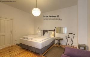 1 dormitorio con 1 cama y luz colgante en Raja Jooseppi Apartments, en Berlín