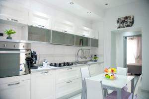 a kitchen with white cabinets and a table with a bowl of fruit at Maiorani Home in Naples