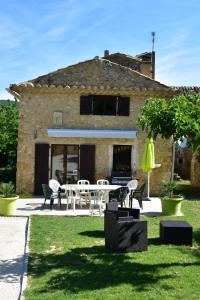 a patio with a table and chairs in front of a building at Gîte La Lichère - La Chanterelle in Saint-Montan