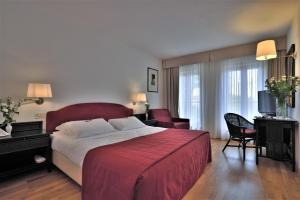 una camera da letto con un grande letto con una coperta rossa di Hotel Hannover a Grado