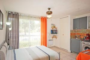 een slaapkamer met een bed en een keuken met een raam bij Studio La Presqu'île 2 in Gruissan