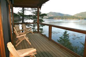 2 Stühle auf einer Veranda mit Seeblick in der Unterkunft Brown's Bay Resort in Campbell River