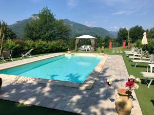 a swimming pool with chairs and a gazebo at Agriturismo Il Frutteto in Ghivizzano