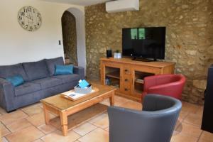 a living room with a couch and a tv at Gîte La Lichère - La Chanterelle in Saint-Montan