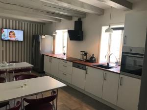 a kitchen with white cabinets and a sink and a table at Det Gamle Apothek in Haslev