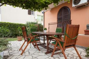 a wooden table and chairs on a patio at Apartments Alice in Rovinj