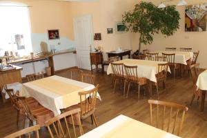 a dining room with tables and chairs and a kitchen at Gasthof Eschau in Palfau