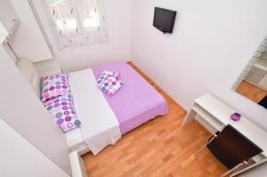 Apartment G.V. في ماكارسكا: غرفة بيضاء صغيرة مع سرير وتلفزيون