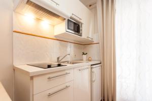 a small kitchen with a sink and a microwave at Apartments Alice in Rovinj +86 photos