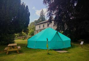 niebieski namiot w trawie obok stołu piknikowego w obiekcie YHA Hawkshead w mieście Hawkshead