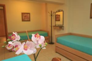 a room with a bed and a table with flowers at Katerina Apartments in Pefkohori