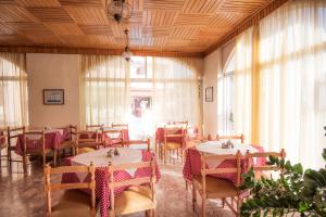 een eetkamer met tafels, stoelen en ramen bij Captain's Hotel in Kos-stad