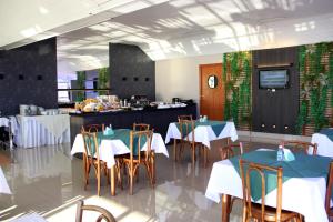 un ristorante con tavoli, sedie e un bancone di Hotel Minuano a Vitória