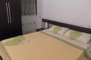 a bed with green and white pillows on it at Dodo's House in Torre Dei Corsari