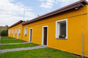 a row of yellow buildings with a window at Apartmány Bowling Frýdlant in Frýdlant
