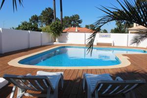 
a patio area with chairs and a pool at Villa near Beach & Lisbon in Corroios
