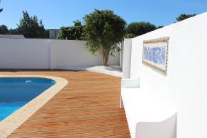 
a white patio with a white wall and a blue and white tile floor at Villa near Beach & Lisbon in Corroios

