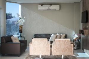 a living room with a couch and two chairs at Ello Hotel in Iguatu