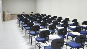 una habitación llena de escritorios y sillas con sillas azules en Ello Hotel, en Iguatu