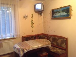 Zimmer mit Sofa und TV an der Wand in der Unterkunft Вікторія in Tatariw