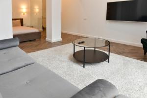 ein Wohnzimmer mit einem Sofa und einem Couchtisch aus Glas in der Unterkunft Luxury Studio next to Monte Carlo in Beausoleil