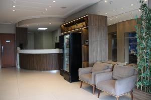 a waiting room with two chairs and a refrigerator at Hotel Minuano in Vitória