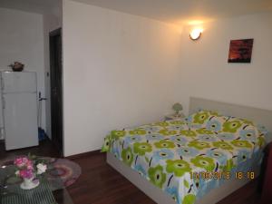 una camera con un letto e un piumone giallo e verde di Vila Mihai a Năvodari