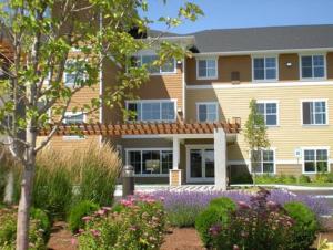 a large building with flowers in front of it at Ledgestone Hotel in Yakima