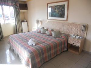 a bedroom with a bed with a plaid blanket at Hotel America in Santa Cruz de la Sierra