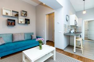 a living room with a blue couch and a table at D8 Design Apartment & Studio in Eger