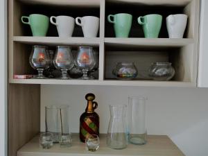 a cabinet filled with glasses and vases on a shelf at Home Torre in Ravenna