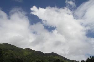 ein wolkiger Himmel über einer Bergkette in der Unterkunft Daniella's Bungalows in Bel Ombre
