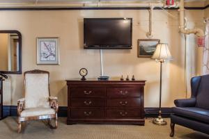 a living room with a tv and a chair and a dresser at Weatherford Hotel in Flagstaff