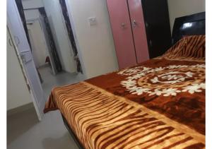 a bed with a brown and white blanket on it at 2BHK Furnished Apartments in Dalhousie