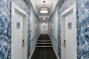 邁阿密海灘的住宿－企鵝酒店，走廊设有蓝色和白色的墙壁和楼梯