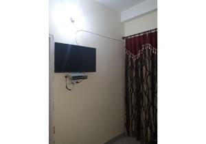 a room with a flat screen tv on the wall at 2BHK Furnished Apartments in Dalhousie