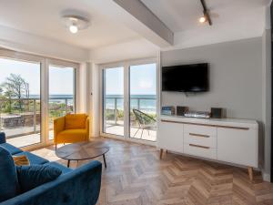 salon z kanapą i telewizorem w obiekcie Al Mare - Apartamenty i pokoje w Sarbinowie
