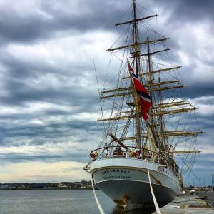 a tall ship sitting in the water with a flag at Apartment Le 1727 in Saint Malo
