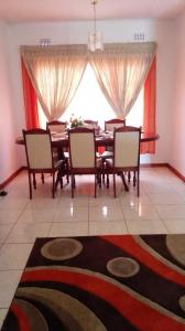 uma sala de jantar com mesa e cadeiras e uma grande janela em Rest Shade Bed and Breakfast em Palapye
