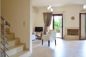 sala de estar con escaleras y sala de estar con mesa y sillas en Ariadni's Maisonette en Yiofirákia