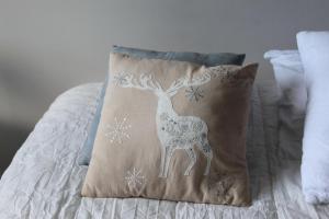 a pillow with a deer on it on a bed at Clos du Pere Ignace in Saint-Martin-de-Ré