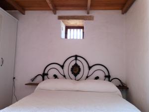 a bedroom with a white bed with a black headboard at Casita rural Molino de La Corte in Antigua