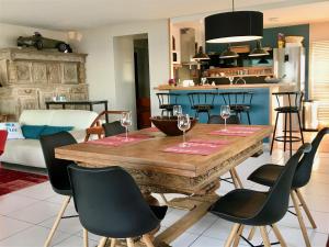 una cocina con una mesa de madera con copas de vino. en Front de mer - Victoria - Appartement 120m2 en Carnac