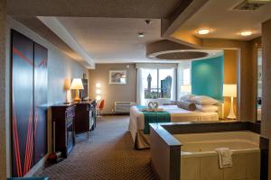 a hotel room with a bed and a tub at Howard Johnson Plaza by Wyndham by the Falls Niagara Falls in Niagara Falls