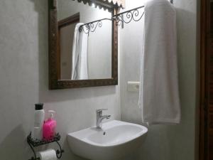uma casa de banho branca com um lavatório e um espelho em DAR ATLAS CHARME em Imlil