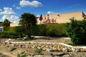 a rock garden with a palm tree and a building at La Siesta in Villamarciel